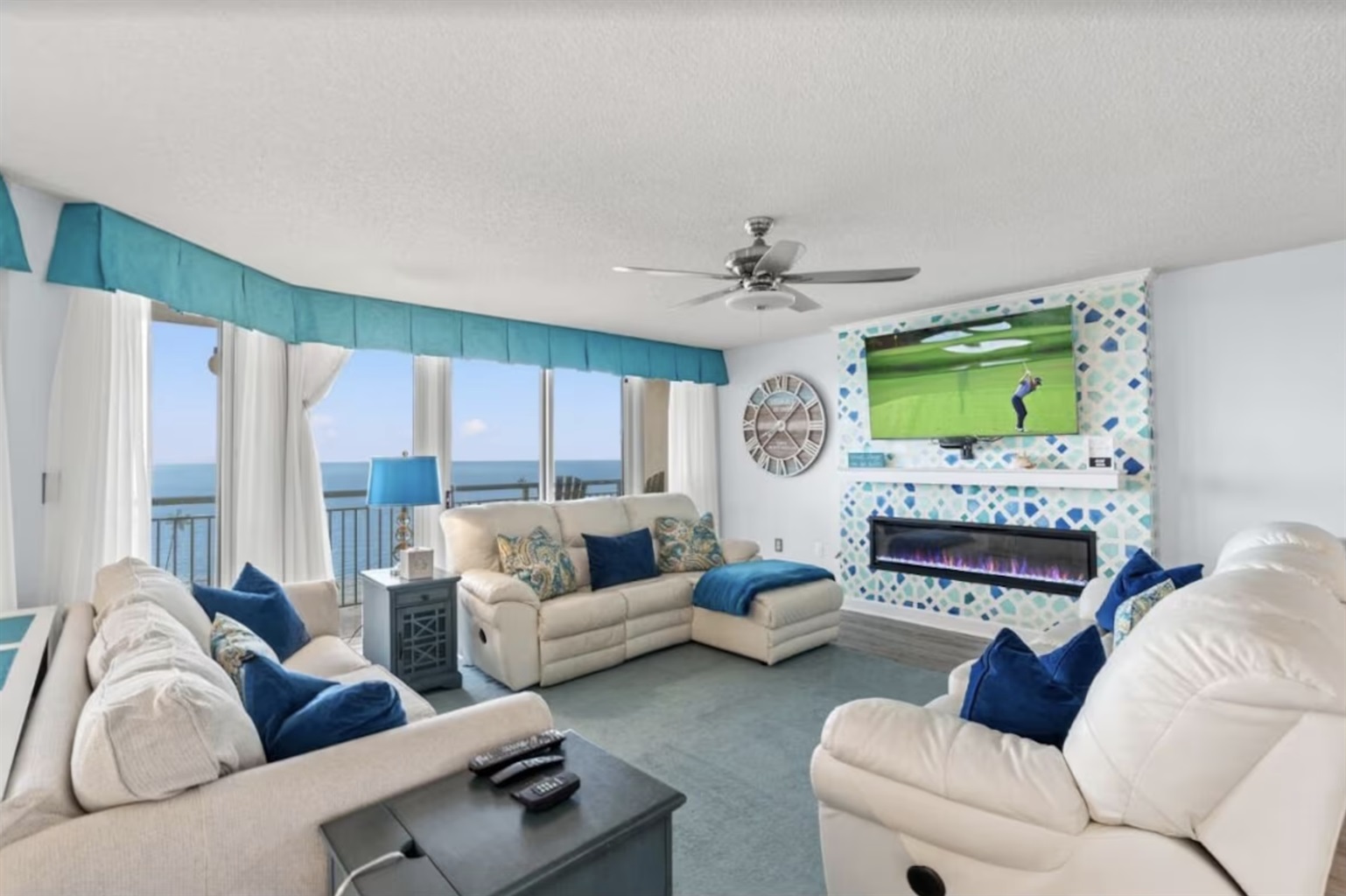 The living room is equipped with ample seating space, an electric fireplace, and a massive 65"+ t