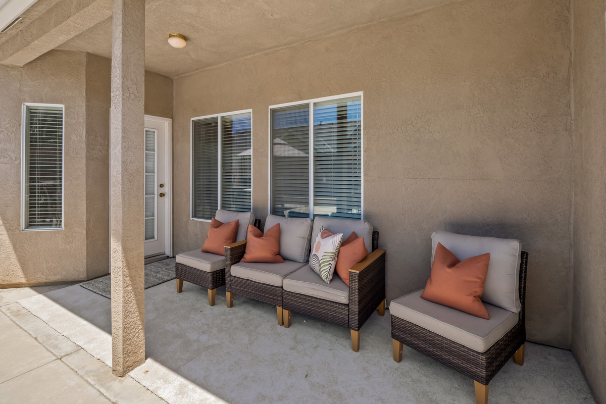 Settle into the cushioned lounge seating and enjoy a peaceful moment in this shaded outdoor retreat, designed for comfort and relaxation.