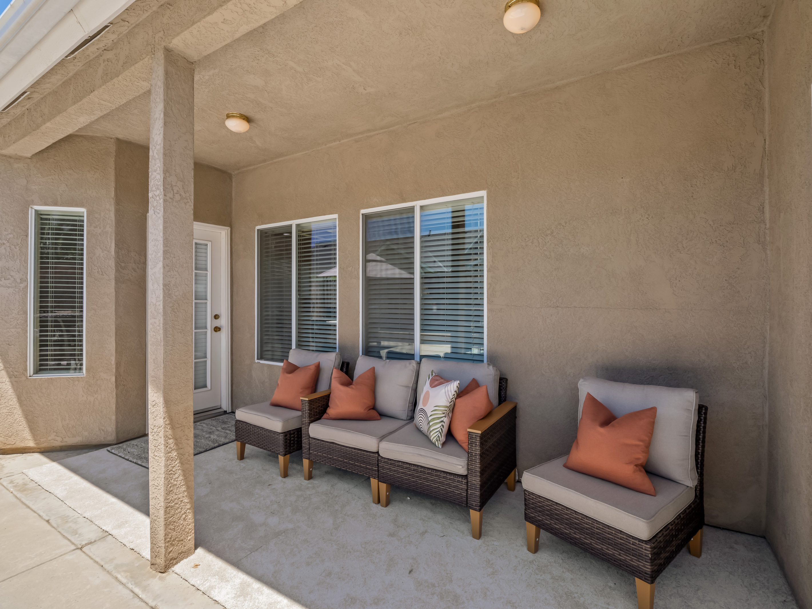 Settle into the cushioned lounge seating and enjoy a peaceful moment in this shaded outdoor retreat, designed for comfort and relaxation.