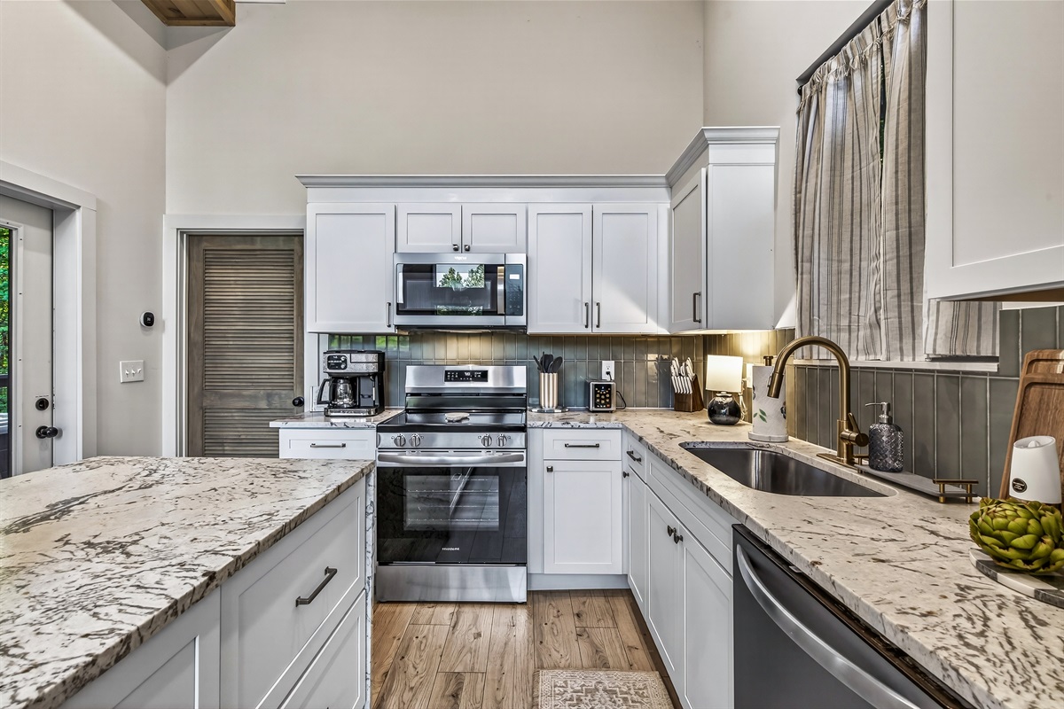 Kitchen has stove, oven with air fryer built in, microwave, toaster, coffee maker for traditional, kuerig and espresso pods along with a dishwasher and fridge