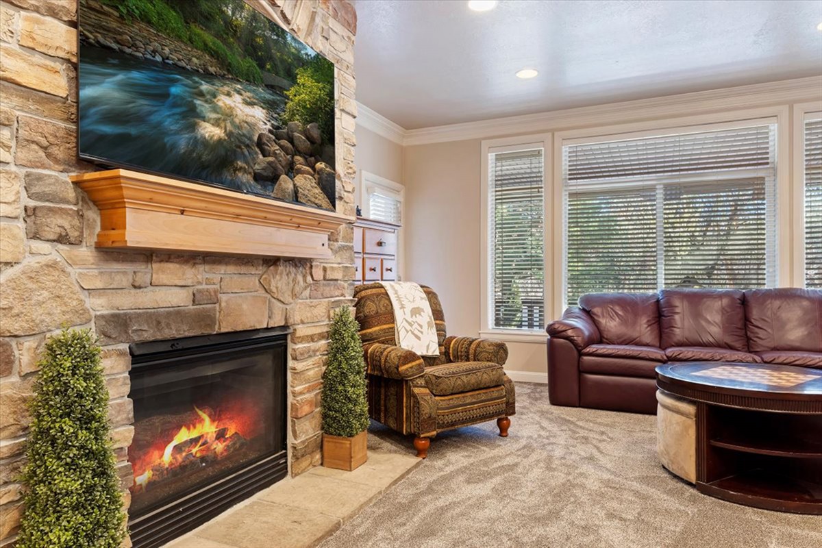 A cozy fireside setting with large windows that fill the space with natural light, creating a warm and relaxing mountain ambiance.