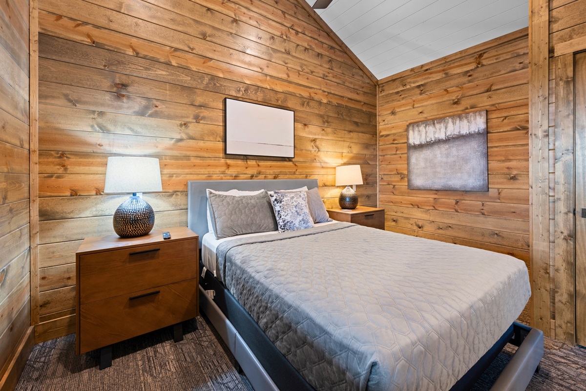 Cozy queen bed with cabin-chic design.
