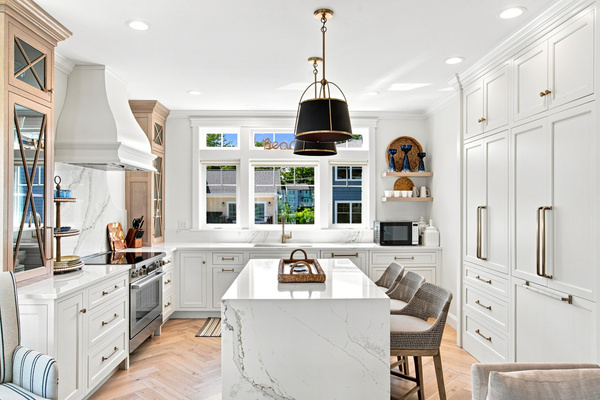 Bright cabinetry, generous workspace, and comfortable seating make this kitchen both stylish and functional.