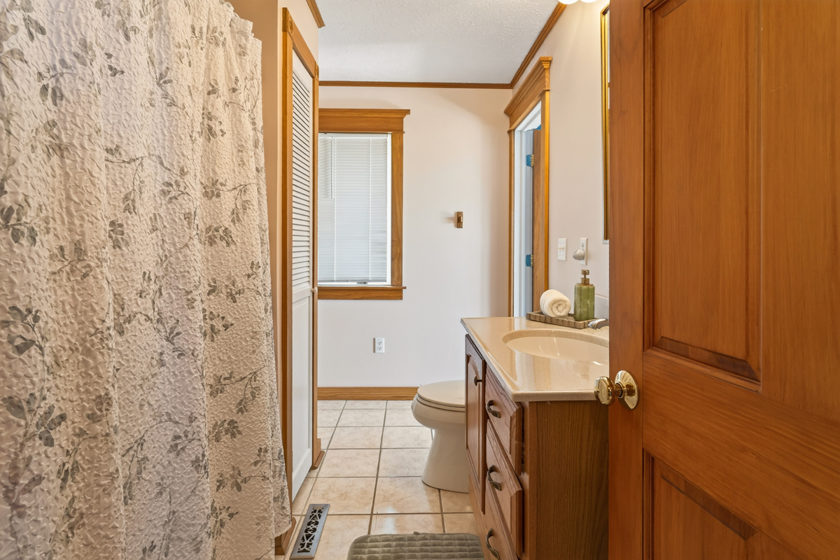 Tiled bathroom with window and vanity