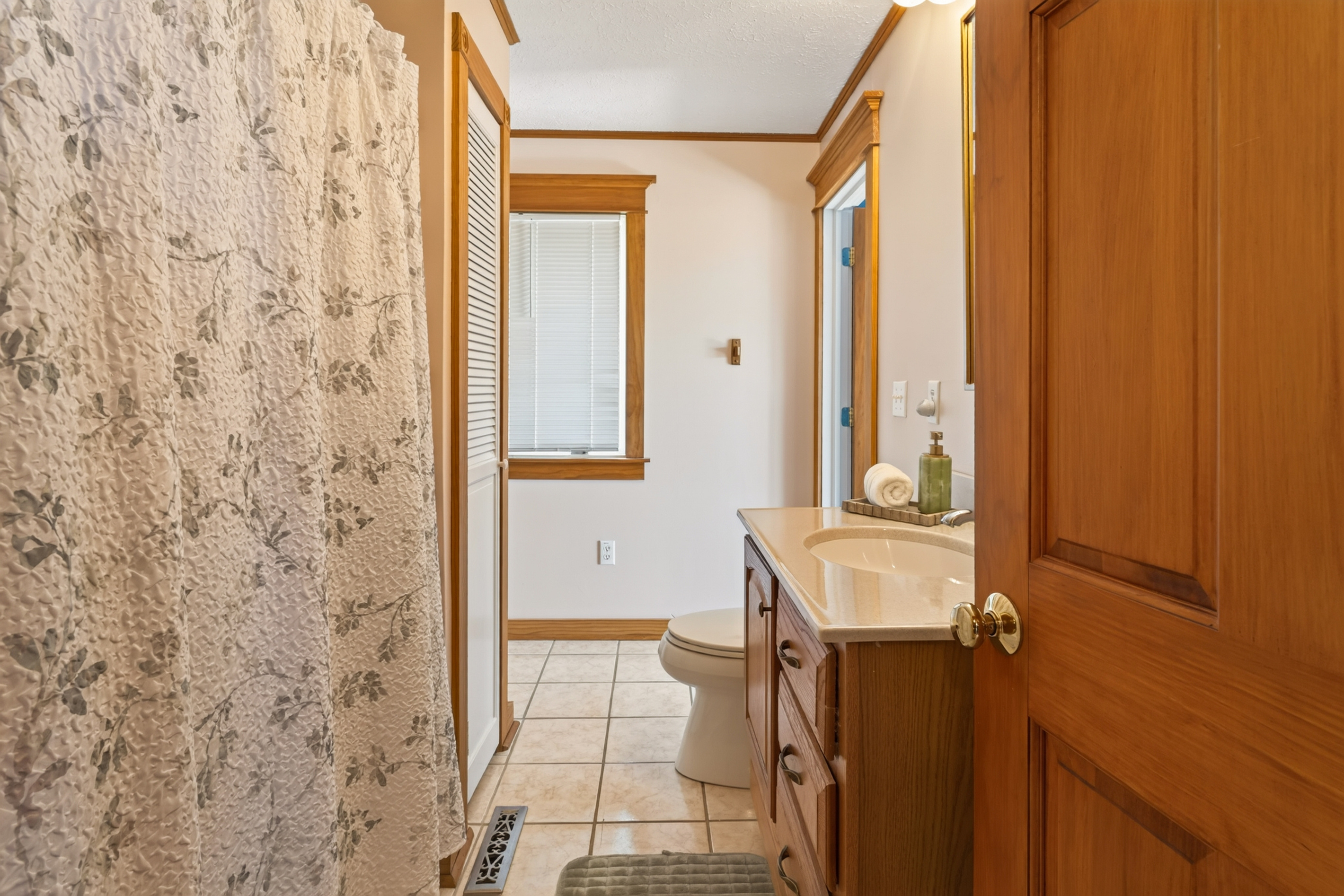 Tiled bathroom with window and vanity