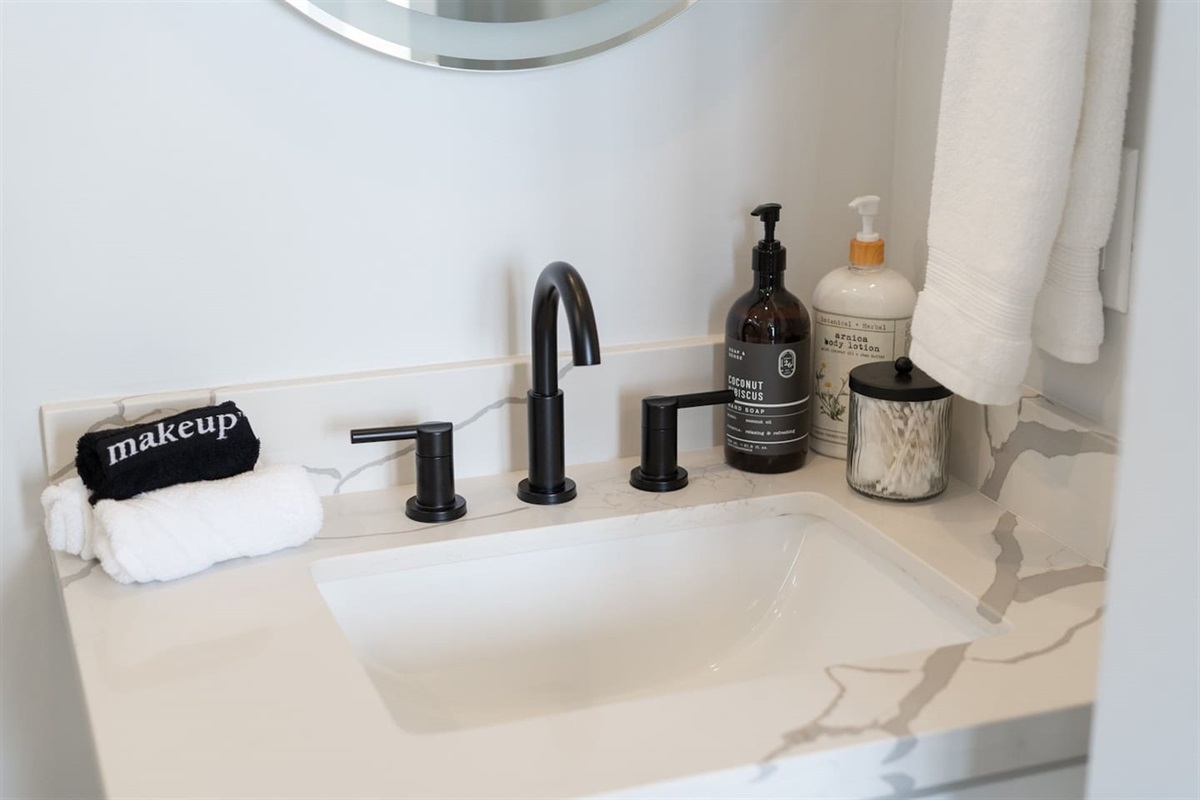 This charming half bathroom includes a modern vanity and toilet, providing a functional and inviting space for guests.