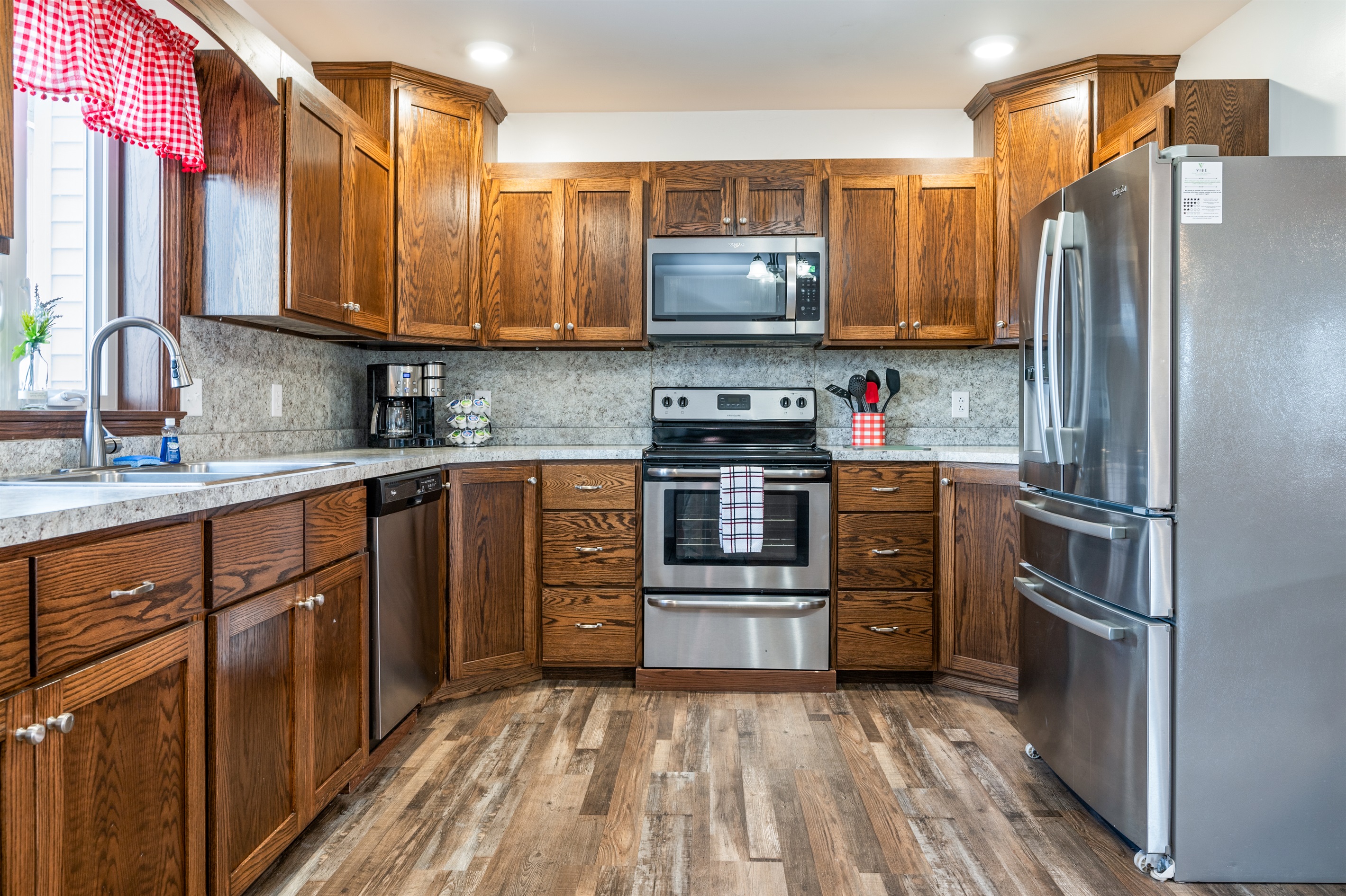 Fully equipped kitchen with stainless steel appliances and warm wood cabinetry.