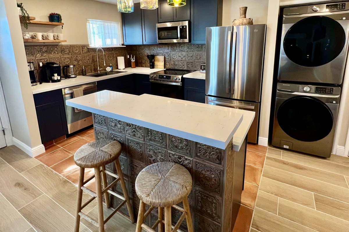 Whip up a meal in the fully-equipped modern kitchen, featuring stainless steel appliances and a stylish breakfast bar with seating for two.