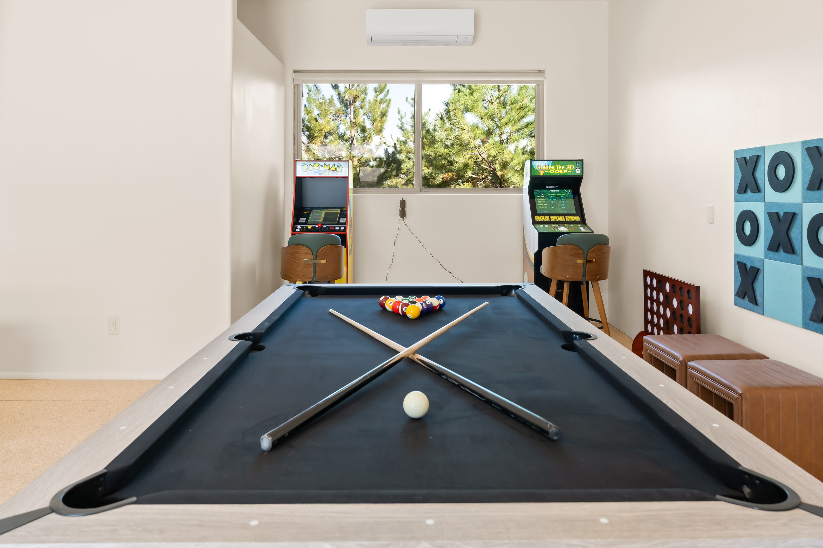 Retro arcade fun featuring classic Pac-Man and Golden Tee machines, full-size pool table, giant wall tic-tac-toe, Connect 4, and climate control 2 Ton mini split.