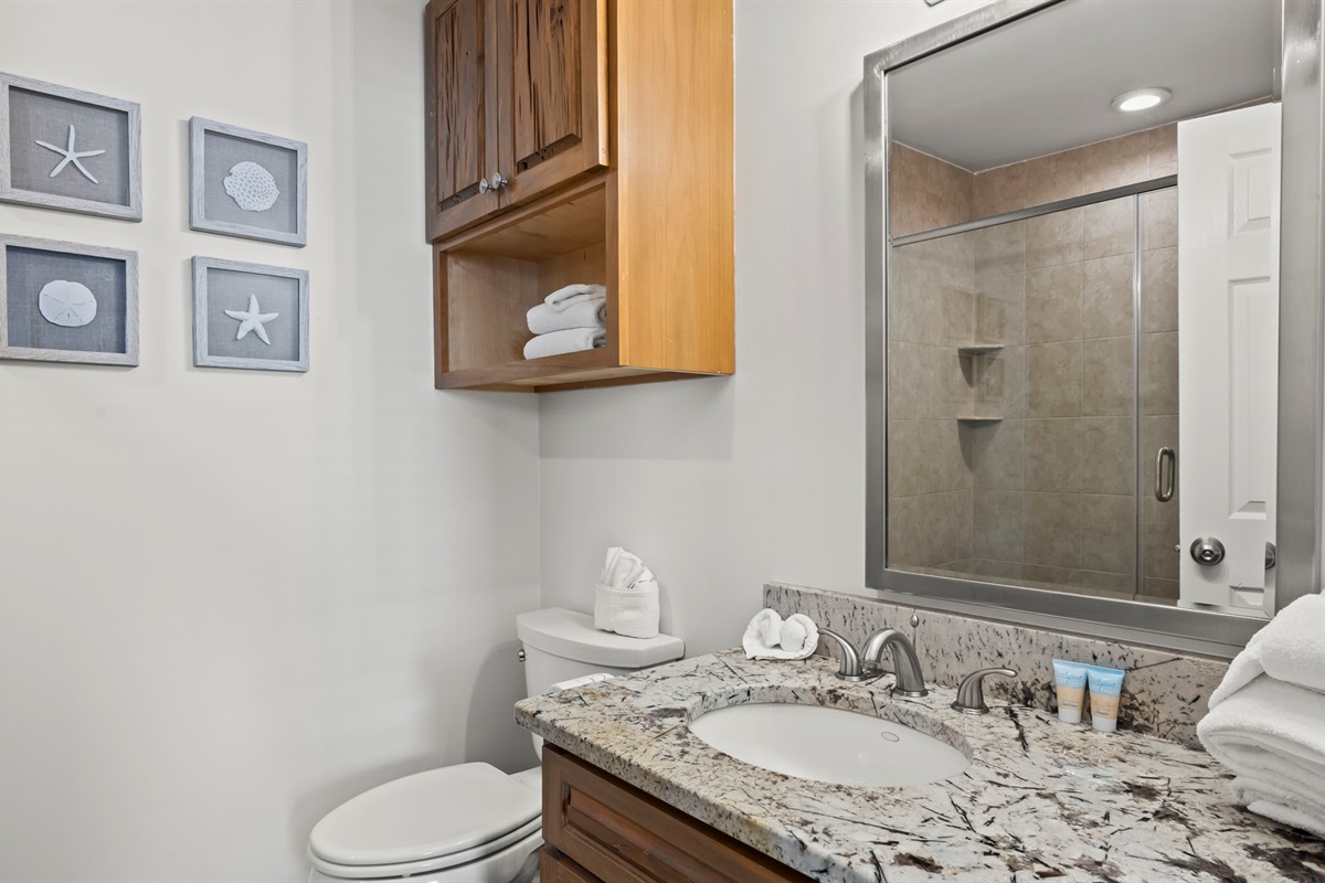 Step into the updated master en suite of our Cotton Bayou condo, featuring modern finishes, dual shower heads for a spa-like experience, and a tranquil atmosphere. The perfect complement to the spacious master suite.