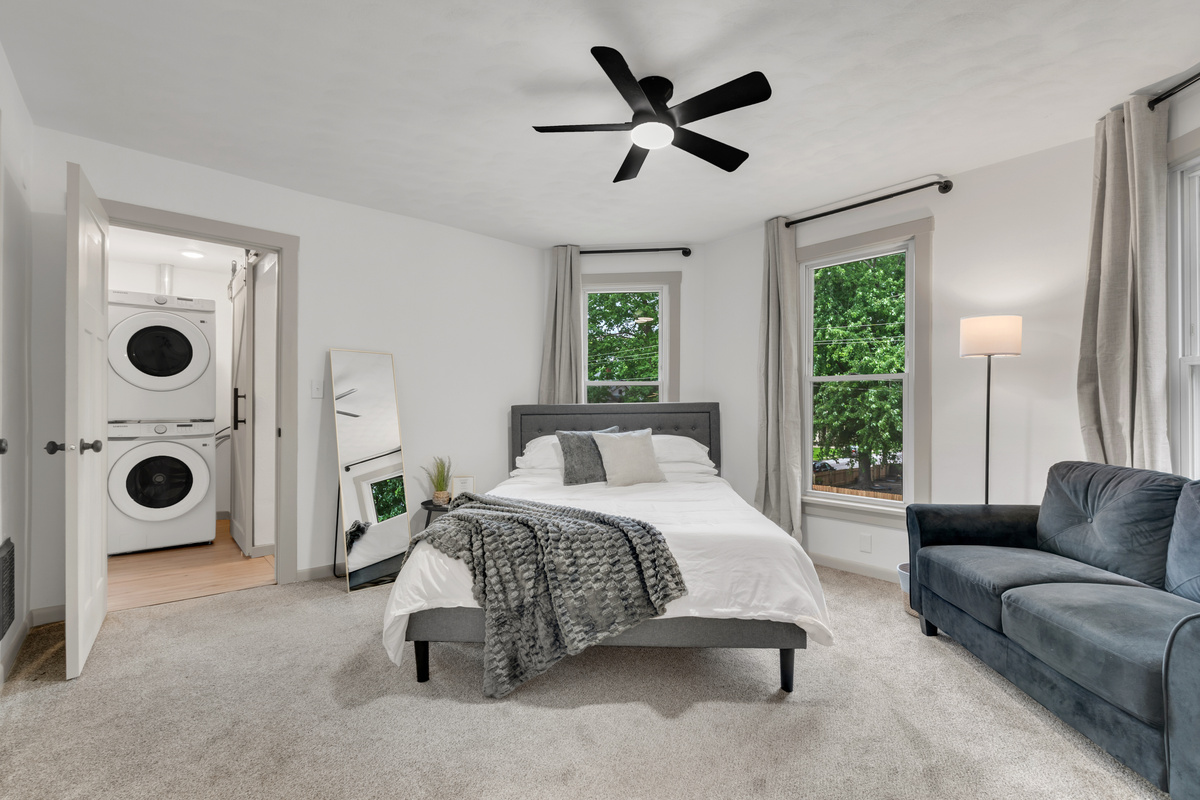Queen bedroom with loveseat, private desk space and smart tv with smart streaming. Also with room darkening curtains.
