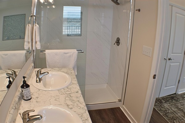 Spa-Like Ensuite: Bright dual vanity and glass shower for your refreshing beach retreat!
