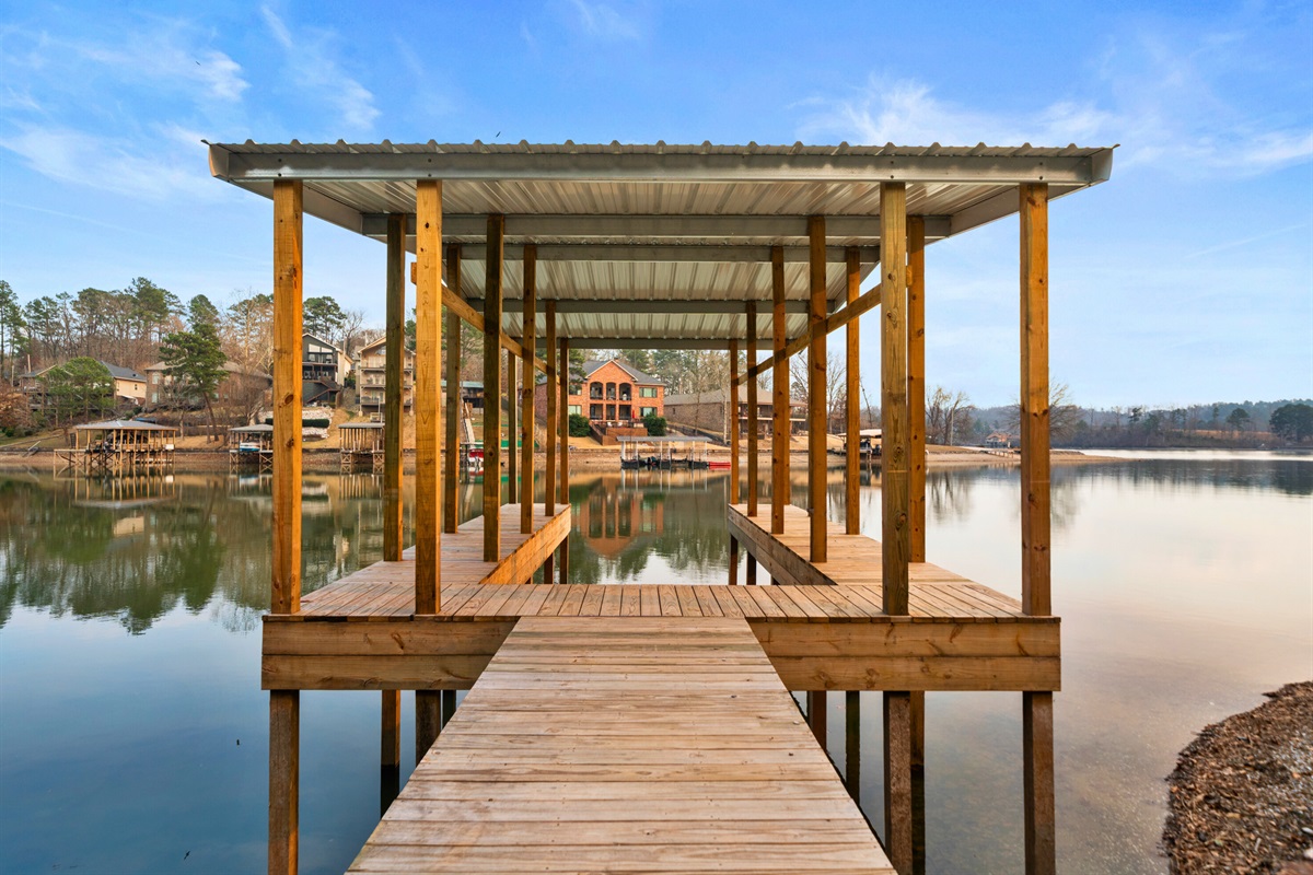 The private dock stretches out over Lake Hamilton, offering an inviting spot for fishing, boating, or simply soaking in the calm water and scenic surroundings.