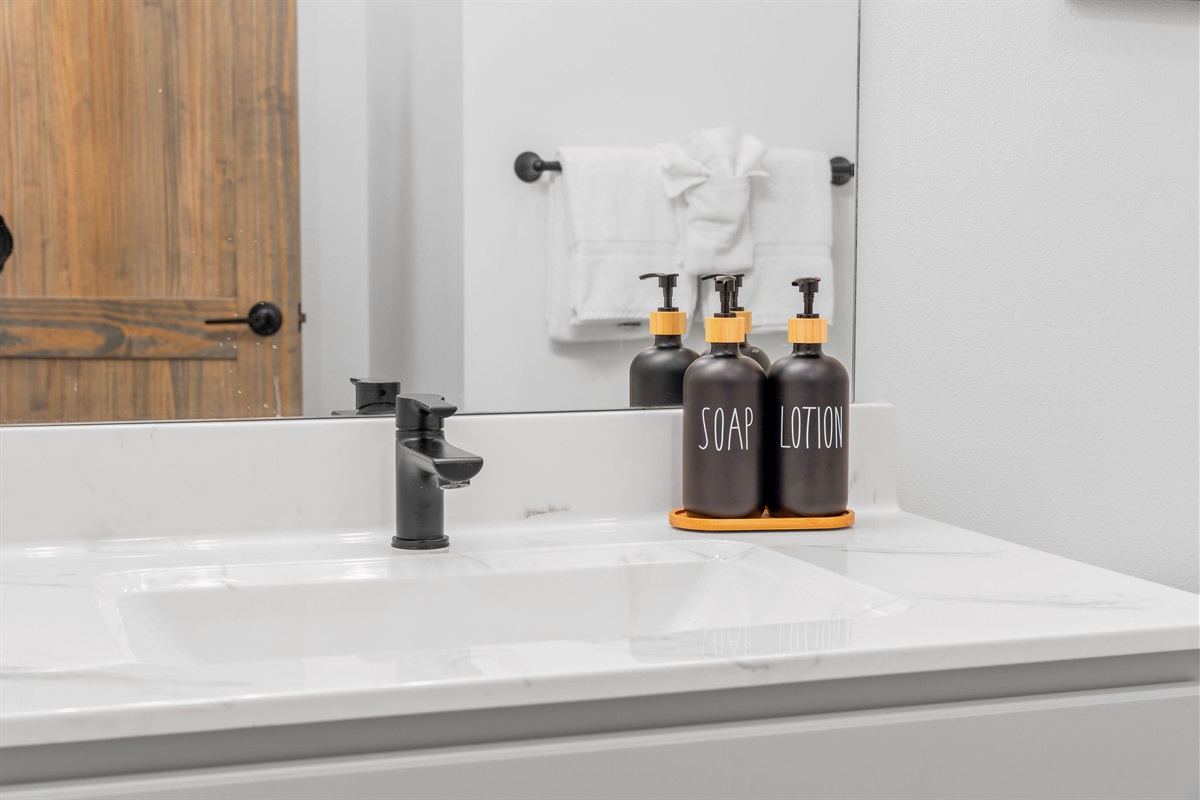 Each of the four bedrooms has a clean, modern bathroom vanity with fresh towels and essential amenities provided.