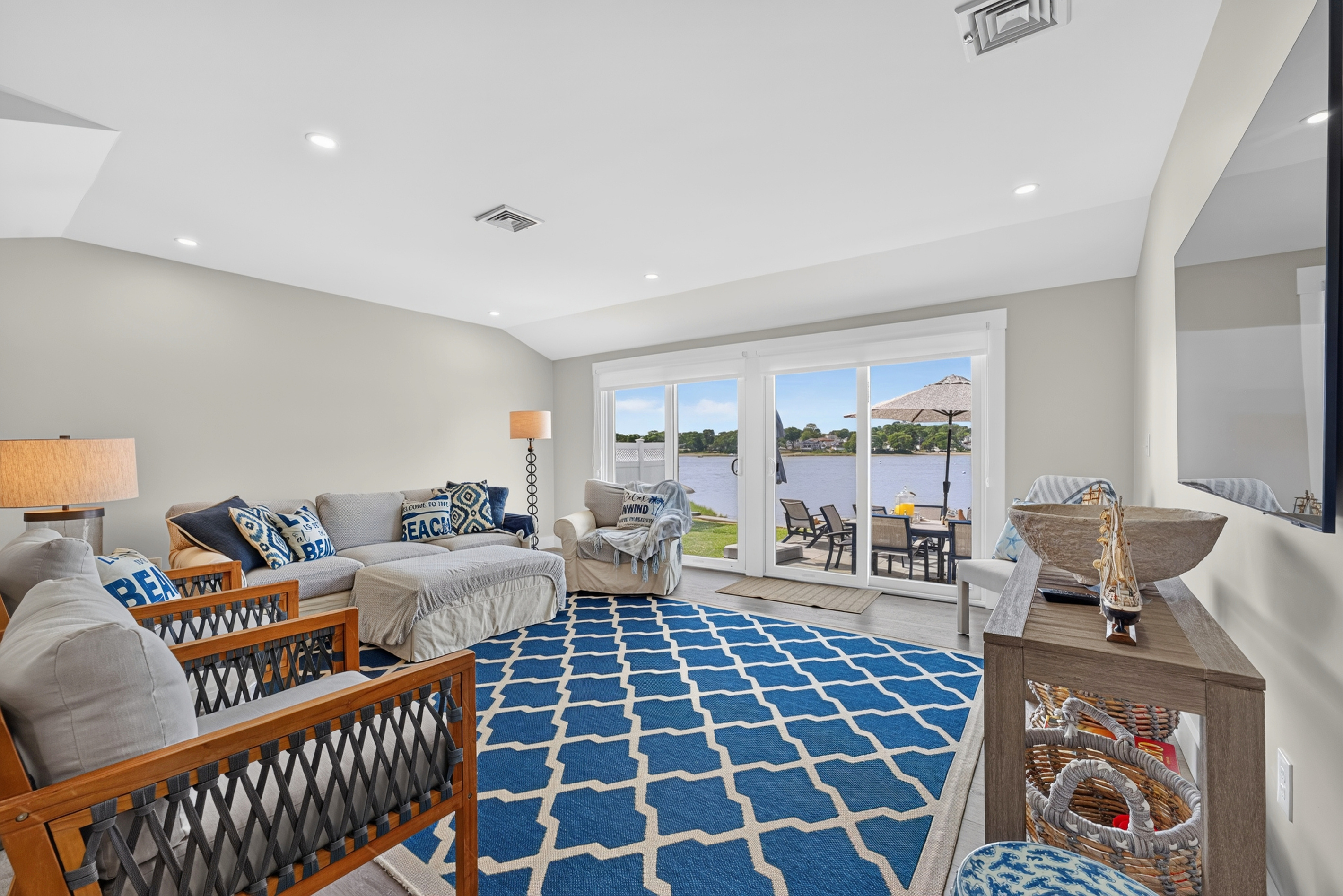 Open living space with waterfront views, comfortable seating, and direct access to the outdoor patio.
