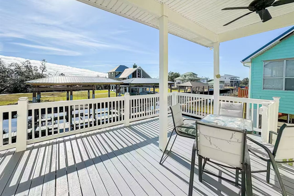 Breezy covered deck with outdoor seating and relaxing neighborhood views—perfect for morning coffee or sunset dinners.