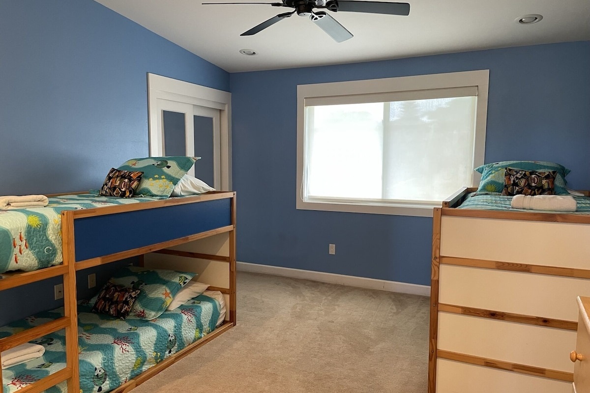 Open style Keiki room with 2 bunk beds and chalkboard wall.