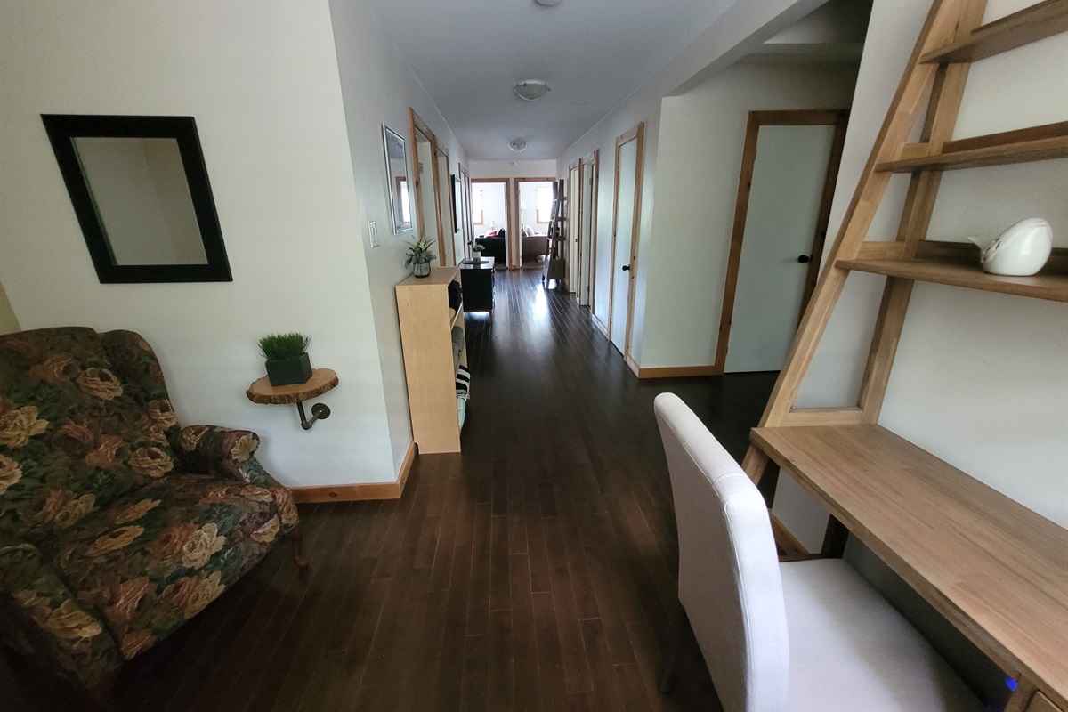 Desk with shelves at one end of hallway with nearby seating