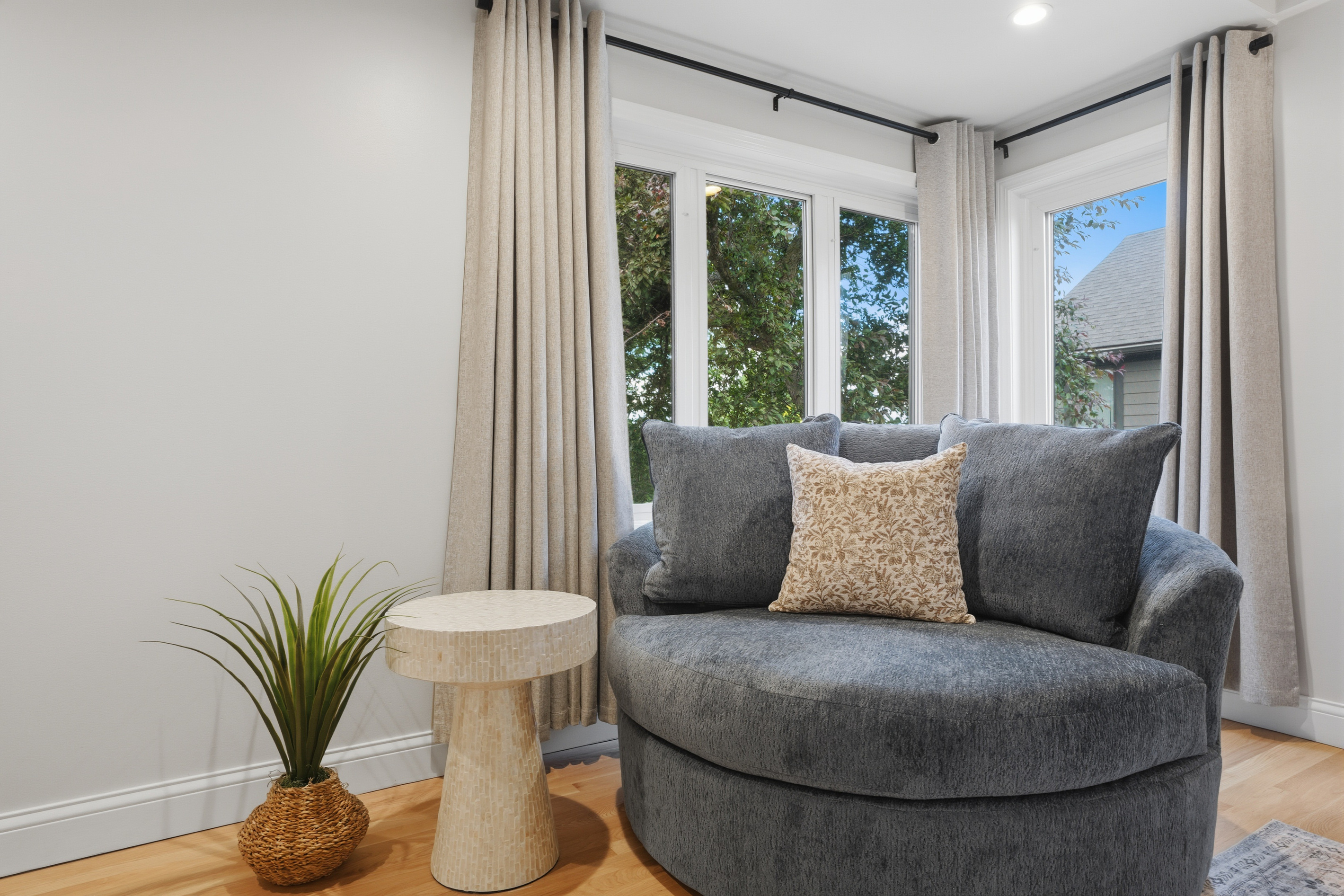 Cozy sitting nook with a plush chair, large windows, and natural light throughout. A calm, inviting corner perfect for reading, relaxing, or enjoying peaceful views.
