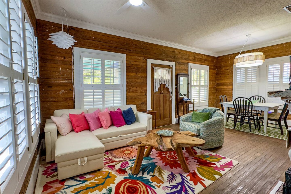 Cozy living area with rich wood walls, colorful accents, and comfortable seating—perfect for relaxing and spending time together.