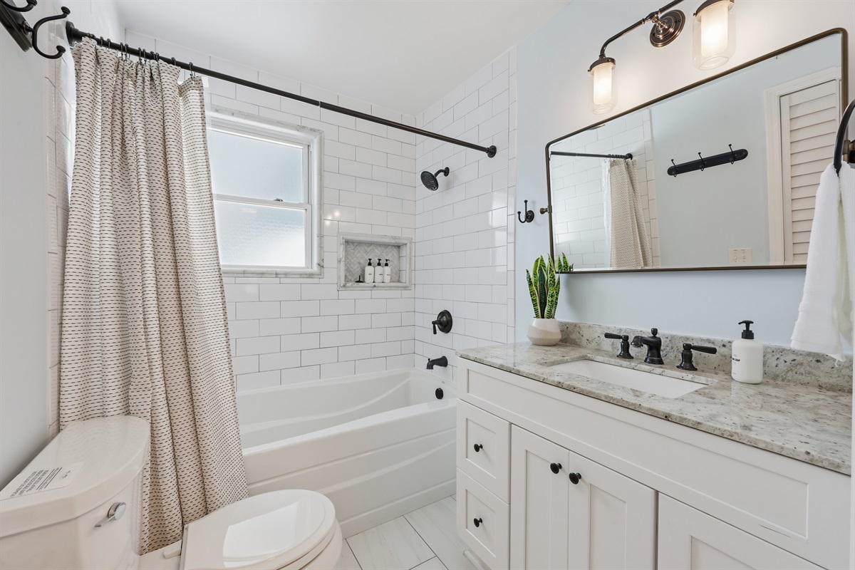 Spa-inspired shared guest hall bathroom with clean finishes and a crisp coastal feel