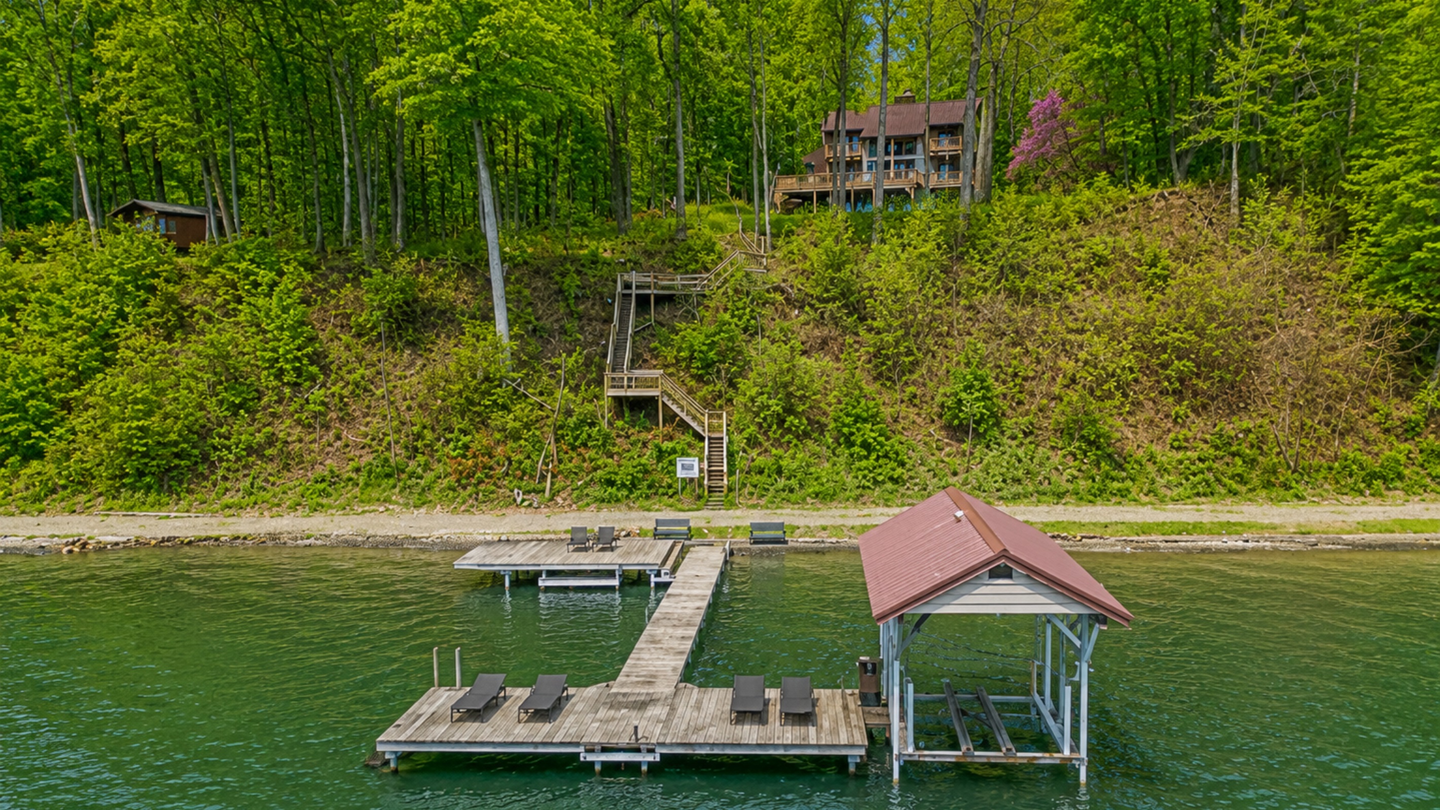 Wooded hillside leads down private steps to the dock on crystal-clear Cayuga Lake—tie up the boat, swim, or soak in Finger Lakes sunsets 🚤🌞🌊Hoist not available