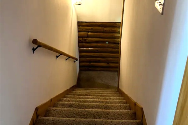 Stairs from the upper level heading to and from the kitchen