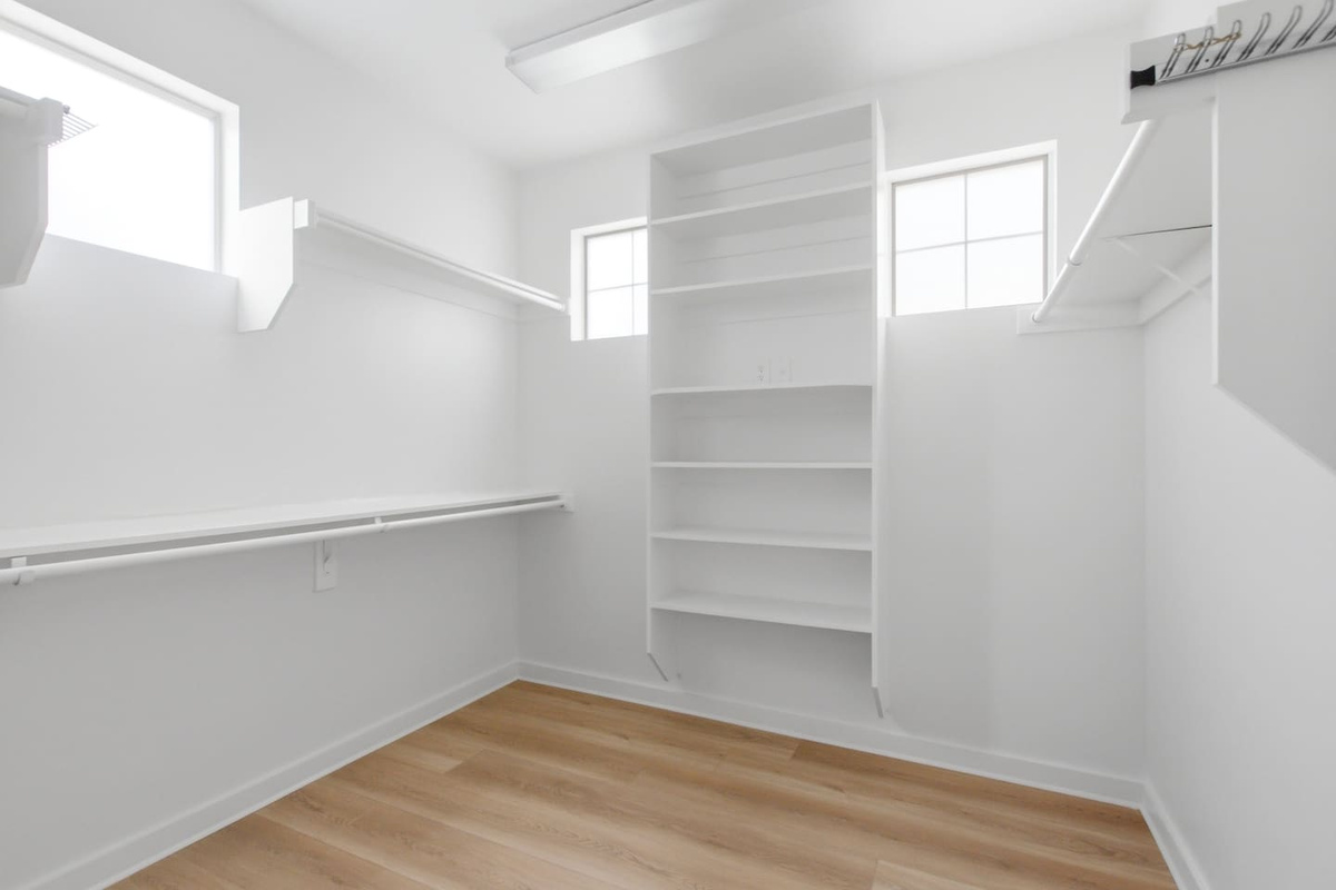 Primary suite walk-in closet with generous built-in shelving on every wall. Plenty of room to fully unpack and settle in, whether you are here for a long weekend or a full week.

