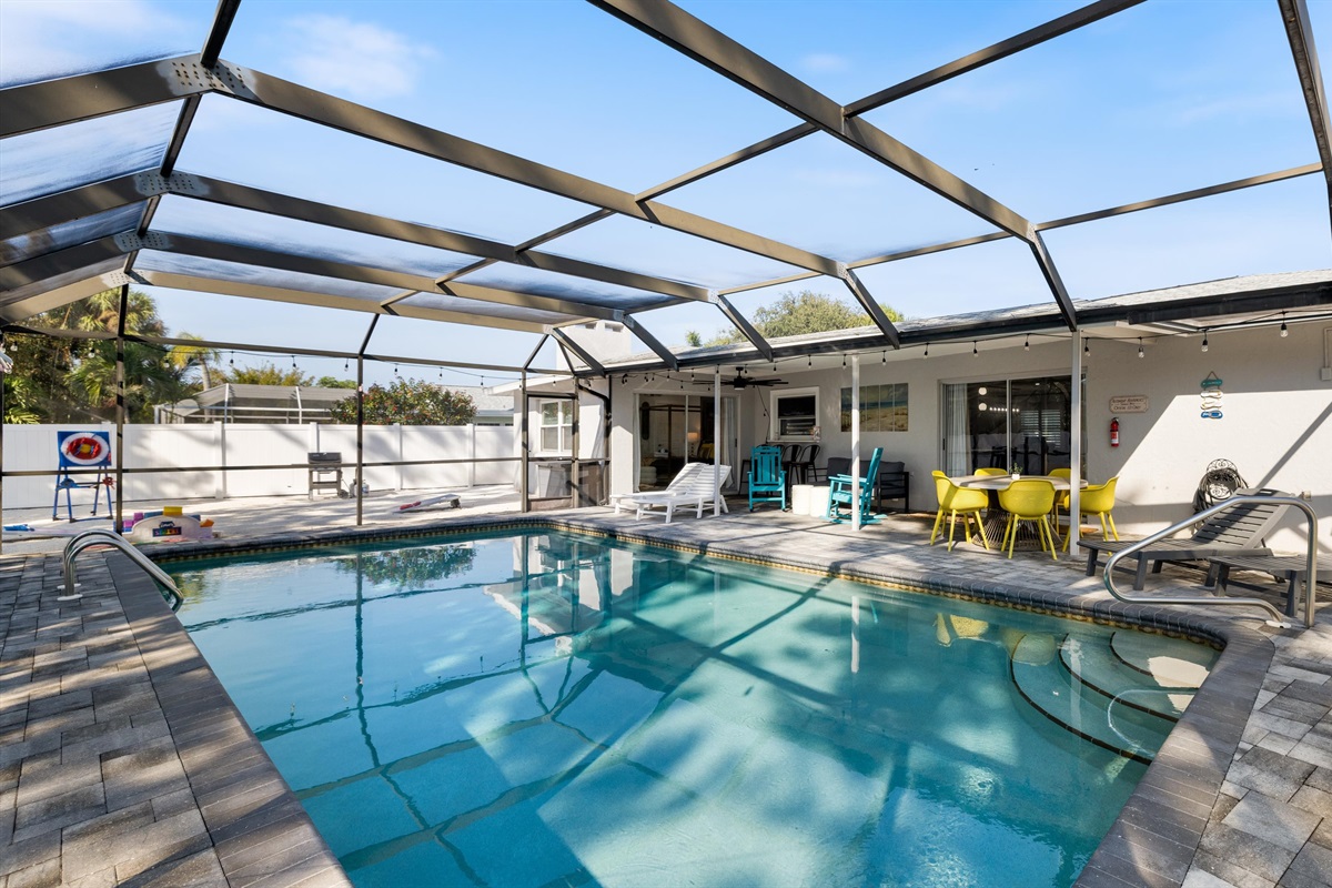 Dip into a crystal-clear pool surrounded by rich greenery and relaxing lounge chairs.