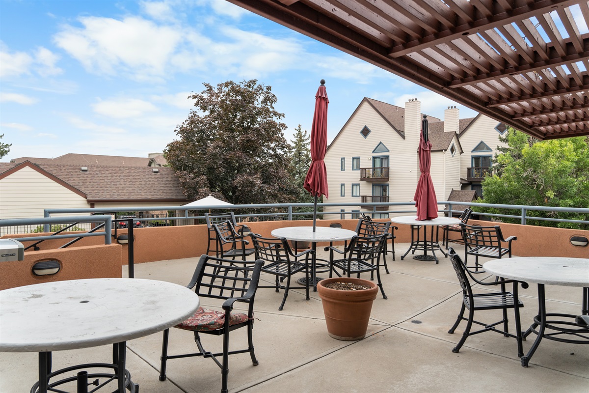 Outdoor seating by pool, gas grill and lounge area