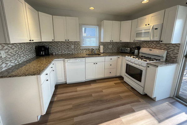 Fully stocked kitchen with gas oven and stove, microwave, dishwasher, Keurig coffee pot and toaster oven