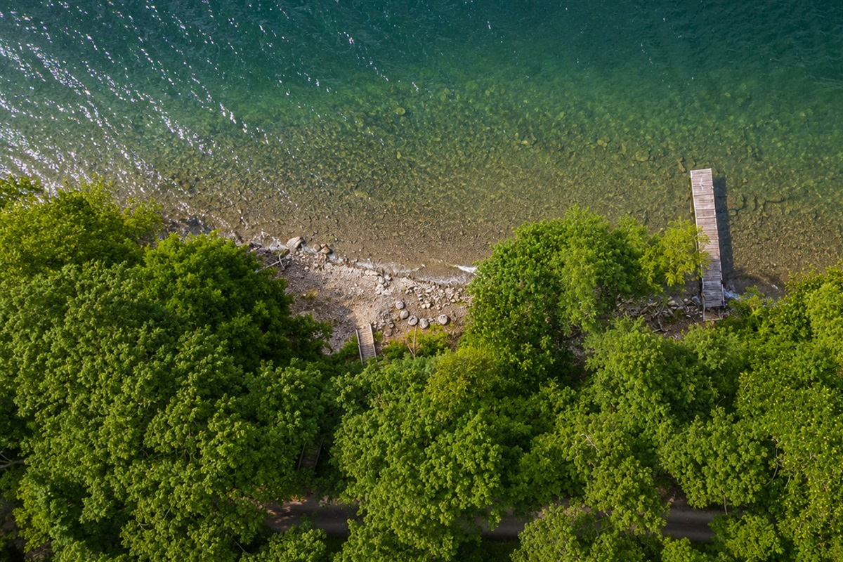 Stunning aerial perspective showcasing lakefront homes with private docks, sandy shoreline, and breathtaking Finger Lakes scenery.