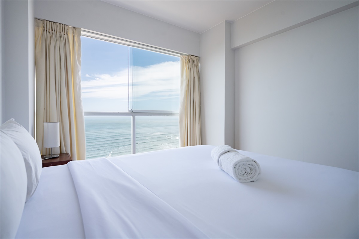 Modern comfort with a queen bed and unforgettable views of the ocean and Malecón  /  Cama queen y vistas inolvidables al océano y al malecón