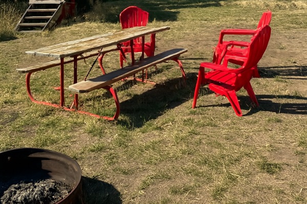 A fire pit, chairs, and picnic table make it easy to relax.