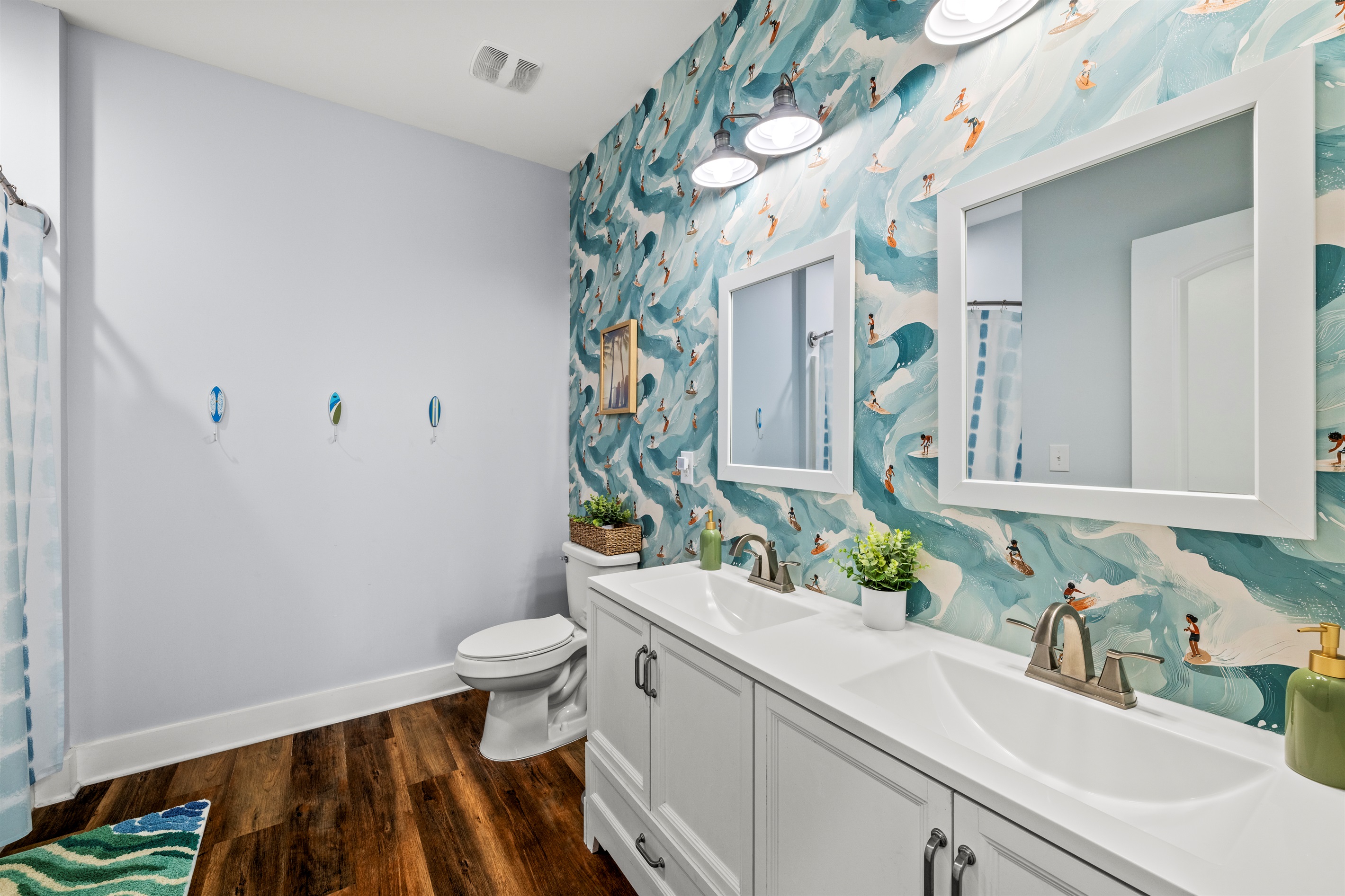 Surf inspired style meets clean modern design. This bright bathroom with double sinks makes getting ready for beach days easy.