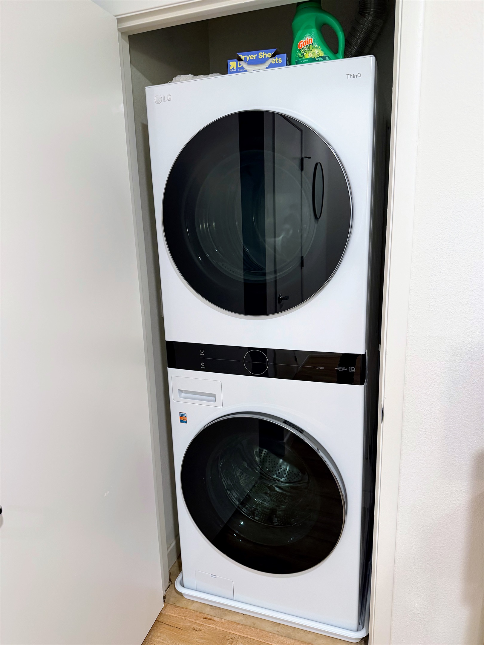 Modern stacked LG front loading washer and dryer near bedrooms.