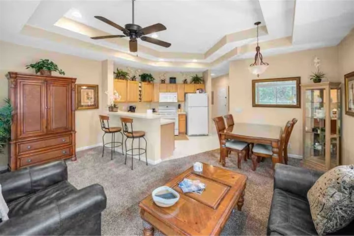 Spacious open-concept living, dining, and kitchen area with high ceilings, comfortable seating, and a bright, welcoming layout.