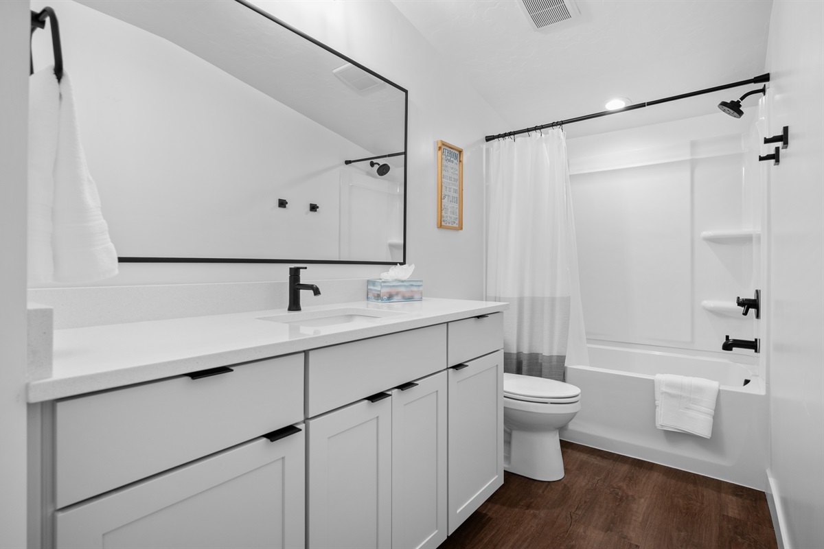 Upstairs bathroom with modern fixtures and a full shower/tub.