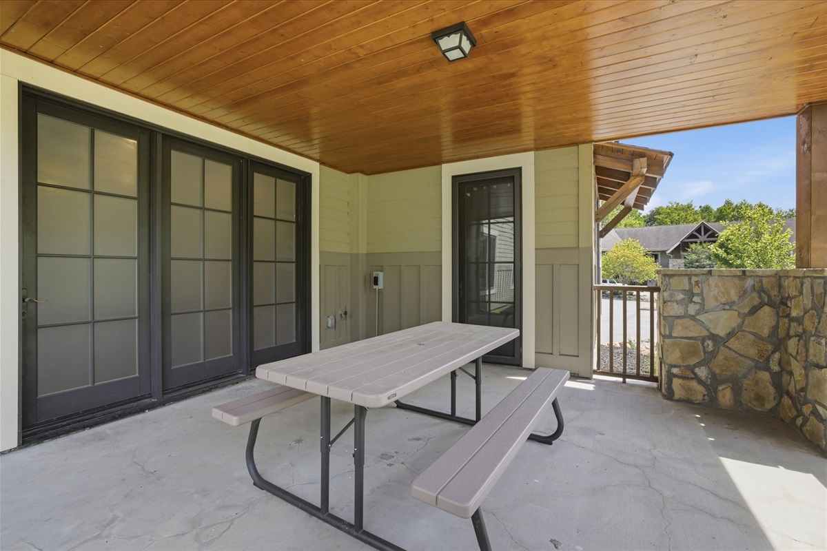 Step out onto the spacious back porch, where a picnic table invites you to gather for meals, morning coffee, or quiet moments surrounded by fresh air.