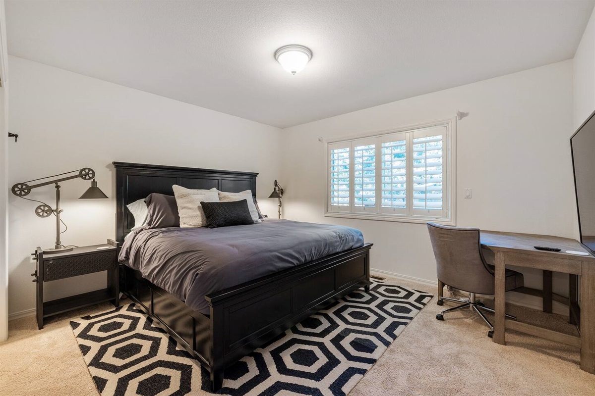 King Guest Bedroom with desk + office chair and 50" 4K TV.