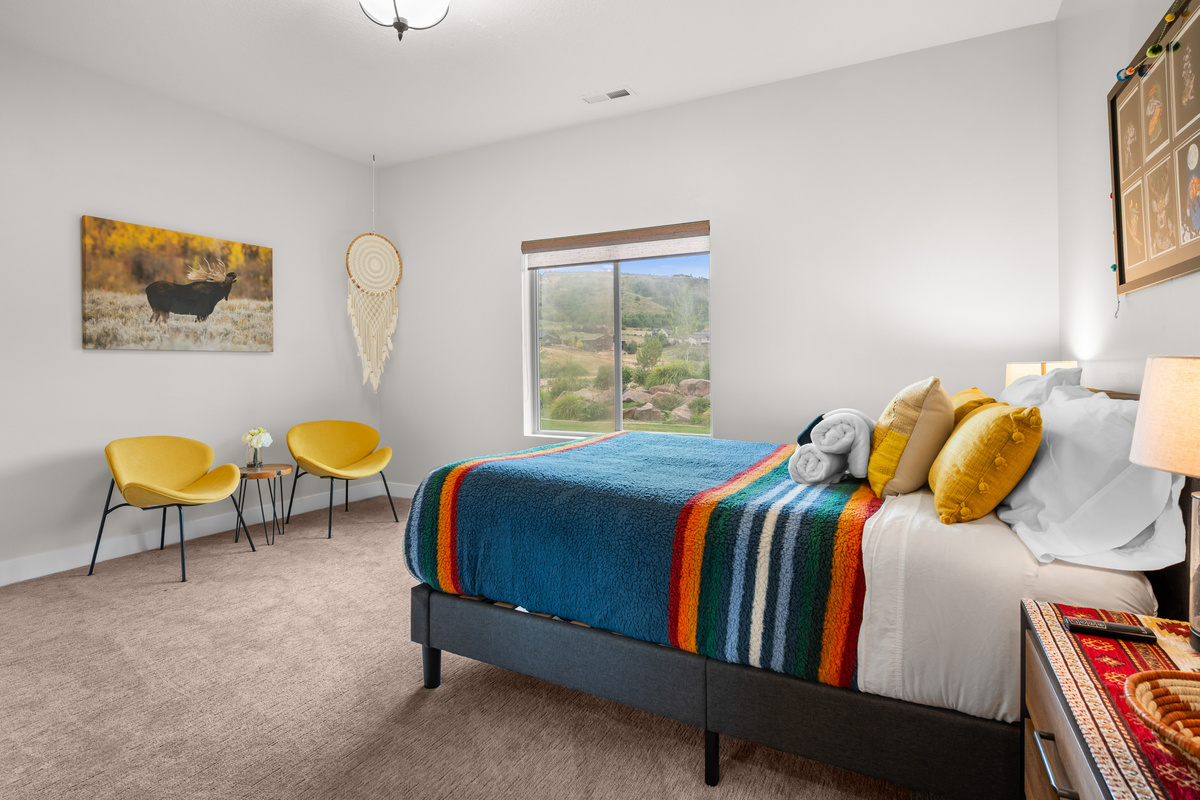 One of two comfortable downstairs queen bedrooms with peaceful natural light and cozy mountain-modern décor.