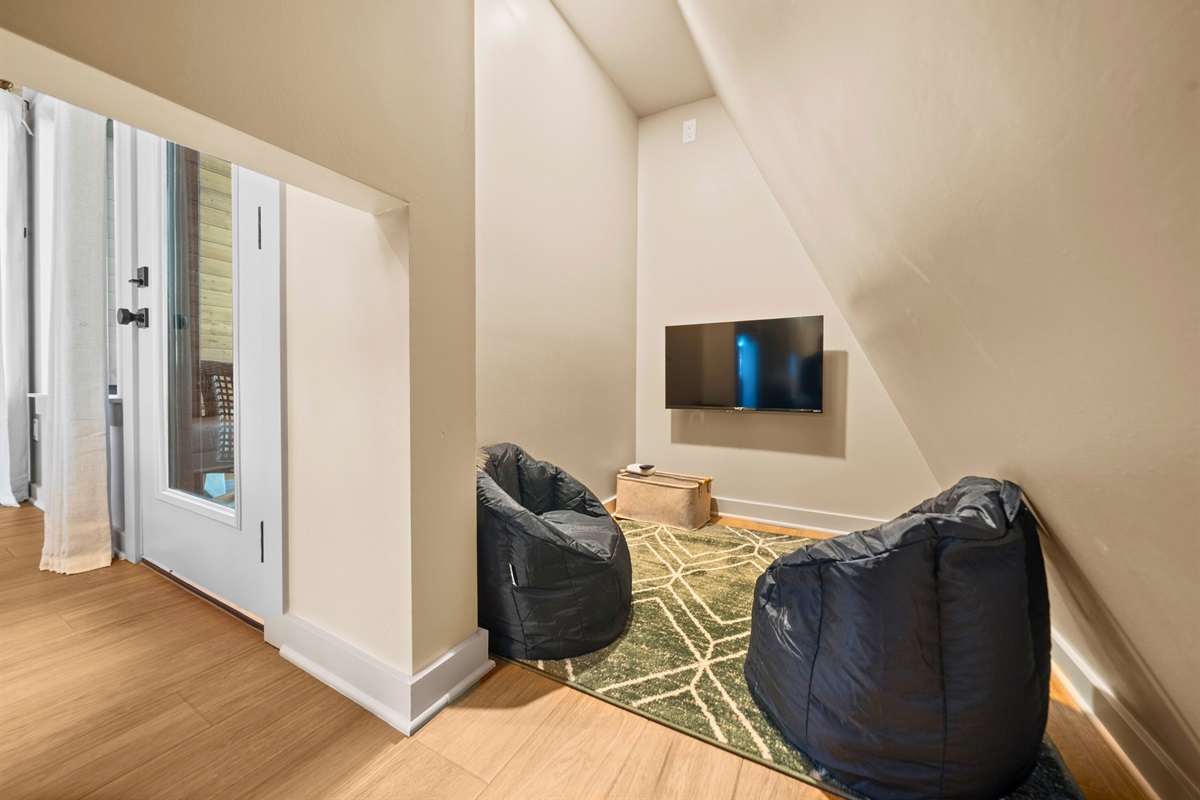 Tucked away behind the sleeping area, this little loft nook feels like a cozy hidden spot where you can curl up with a book, scroll in peace, or sneak away for a quiet moment to yourself.