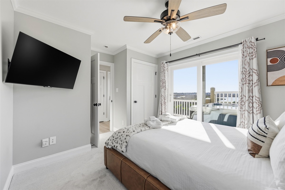 1st-floor queen bedroom #1 with marsh-view balcony access, Smart TV, and private ensuite bathroom
