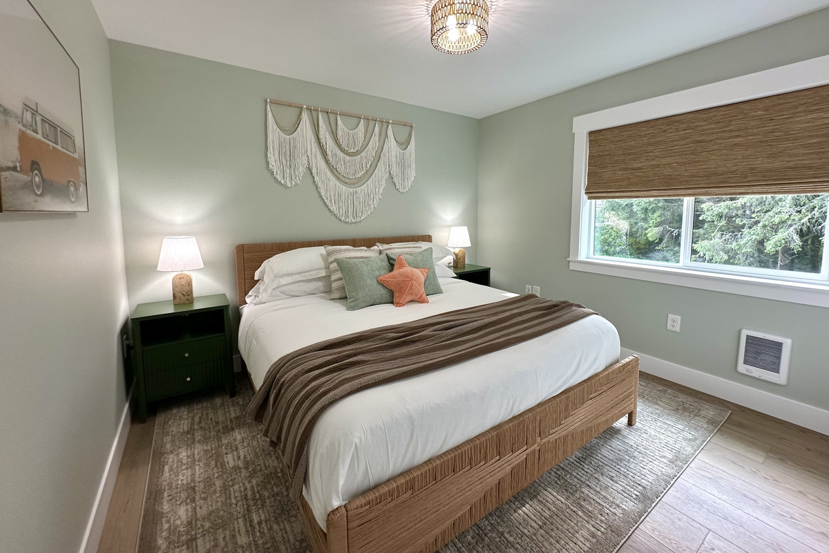 Upstairs, the primary suite: a king bed, coastal-calm palette, dual nightstands and plenty of outlets for everyone's devices.