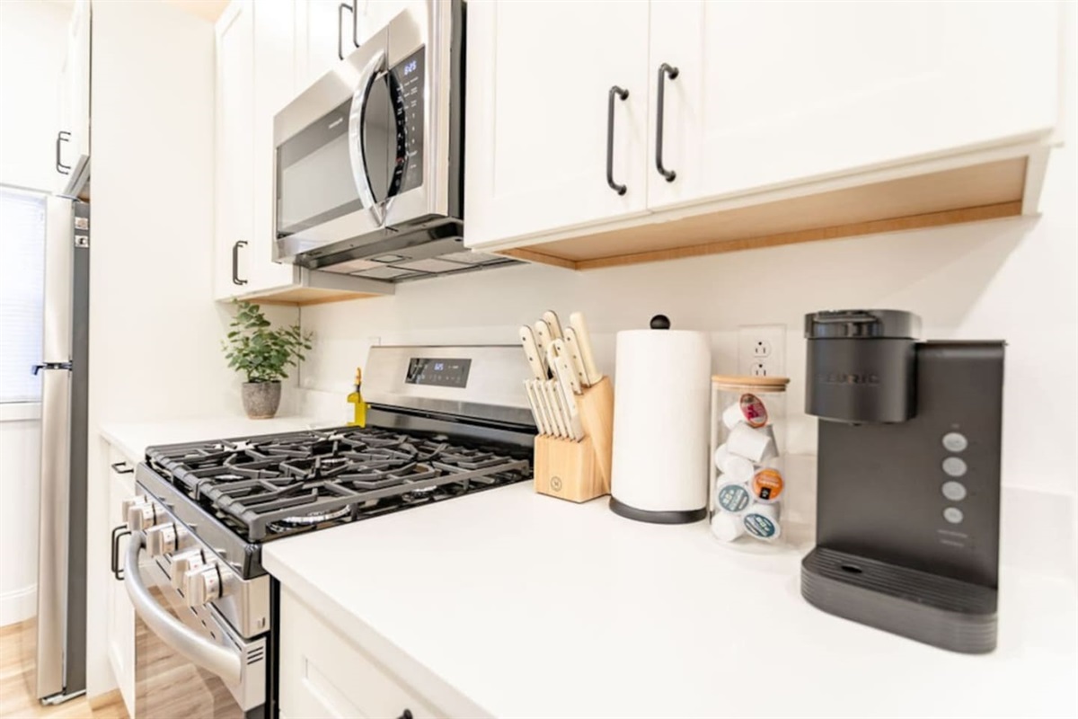View of the kitchen featuring a gas range, coffee maker, and a set of knives, fully equipped for your cooking needs.