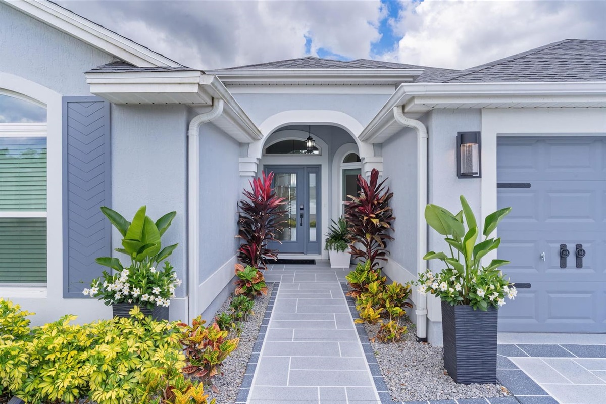 Elegant front entryway with lush landscaping