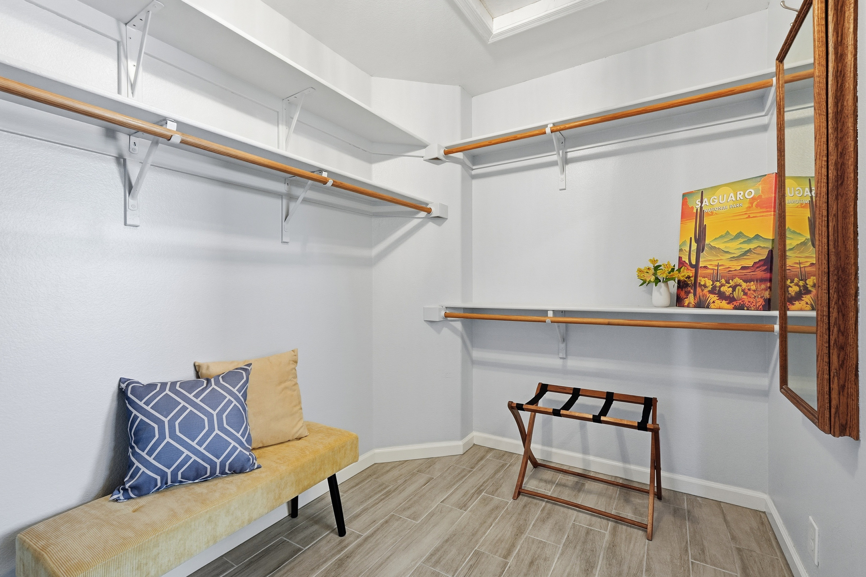 Walk-in closet with open shelving, hanging space, fresh towels, and a bench for easy unpacking during your stay.