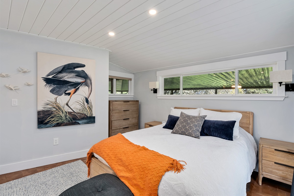 Serene primary bedroom with plush bedding and calming natural light.