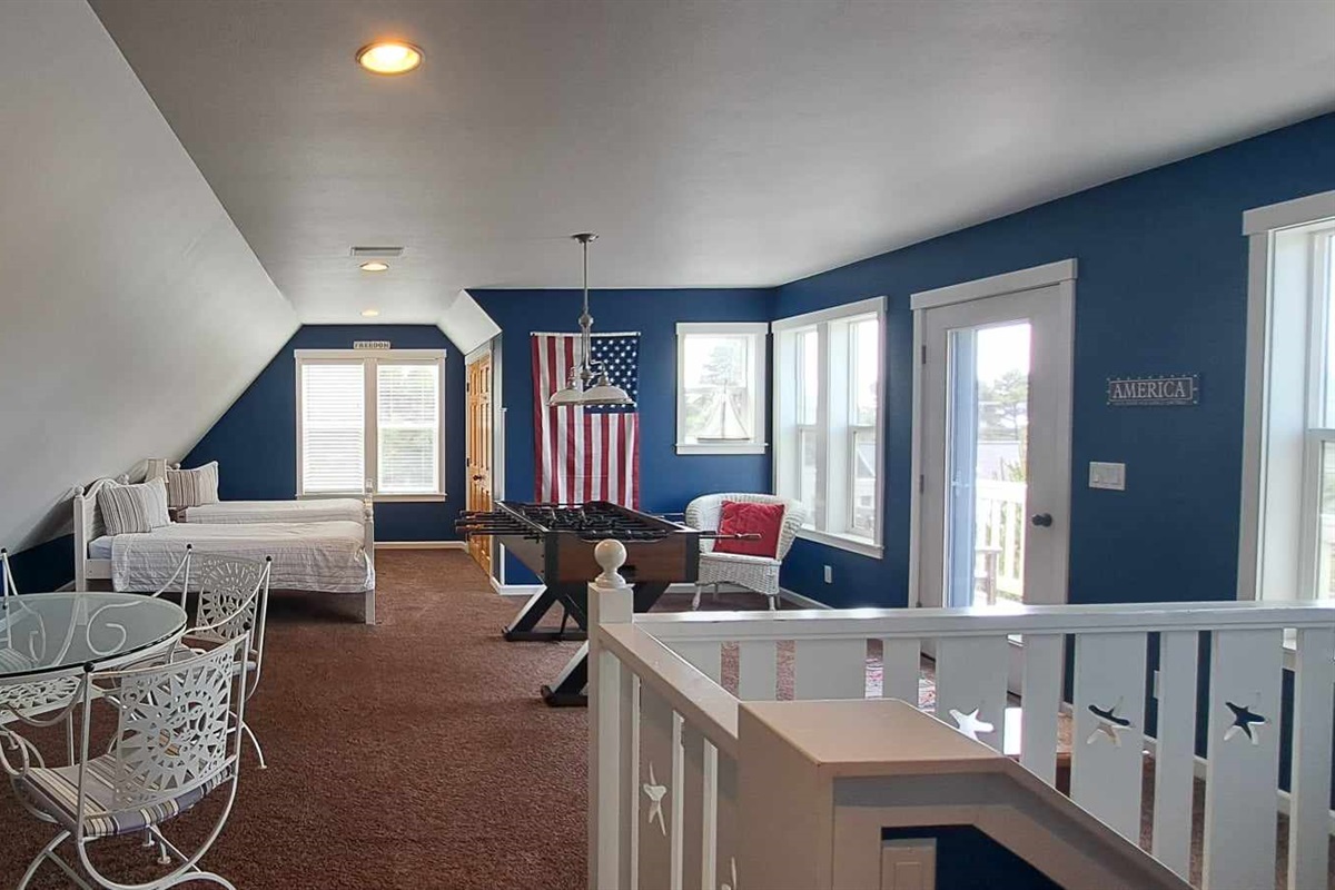 Fun-filled top-floor loft with twin beds, an air hockey and game table, plus a peek of the ocean from the deck and a refreshing coastal breeze.