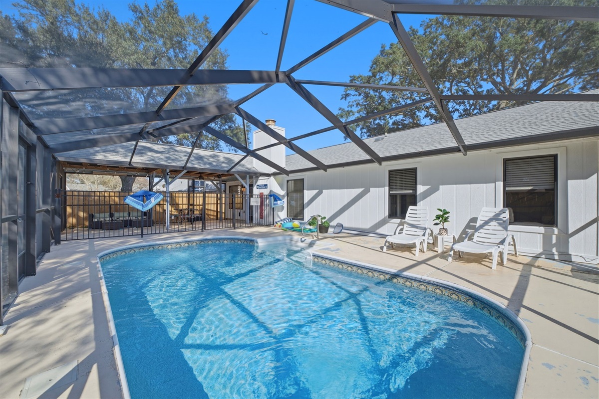 Enjoy your own backyard retreat featuring a sparkling private pool within a large screened enclosure. The surrounding deck and lounge seating create a comfortable setting for relaxing between swims.
